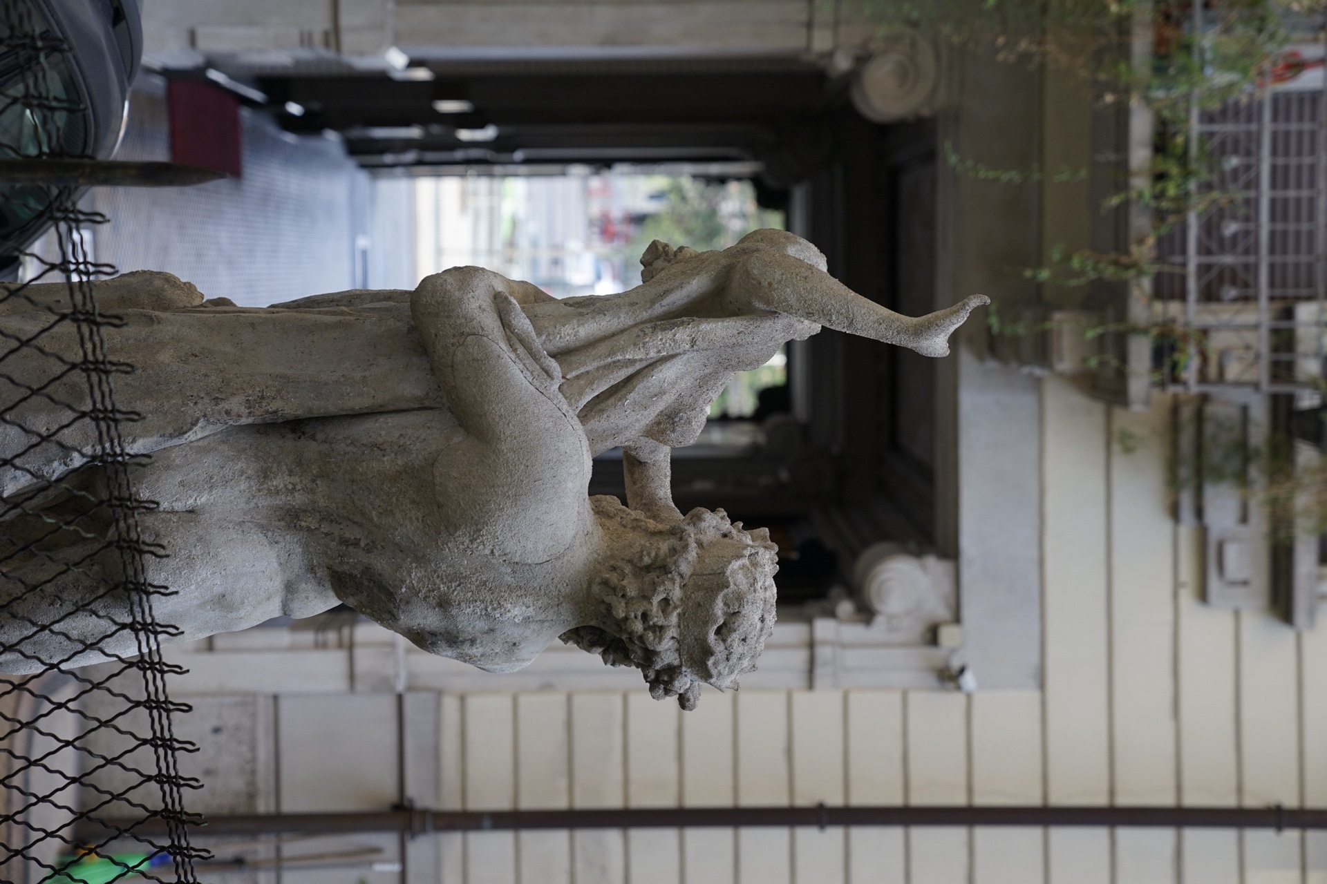 Atrio del palazzo storico milanese, statua classica e colonna ionica